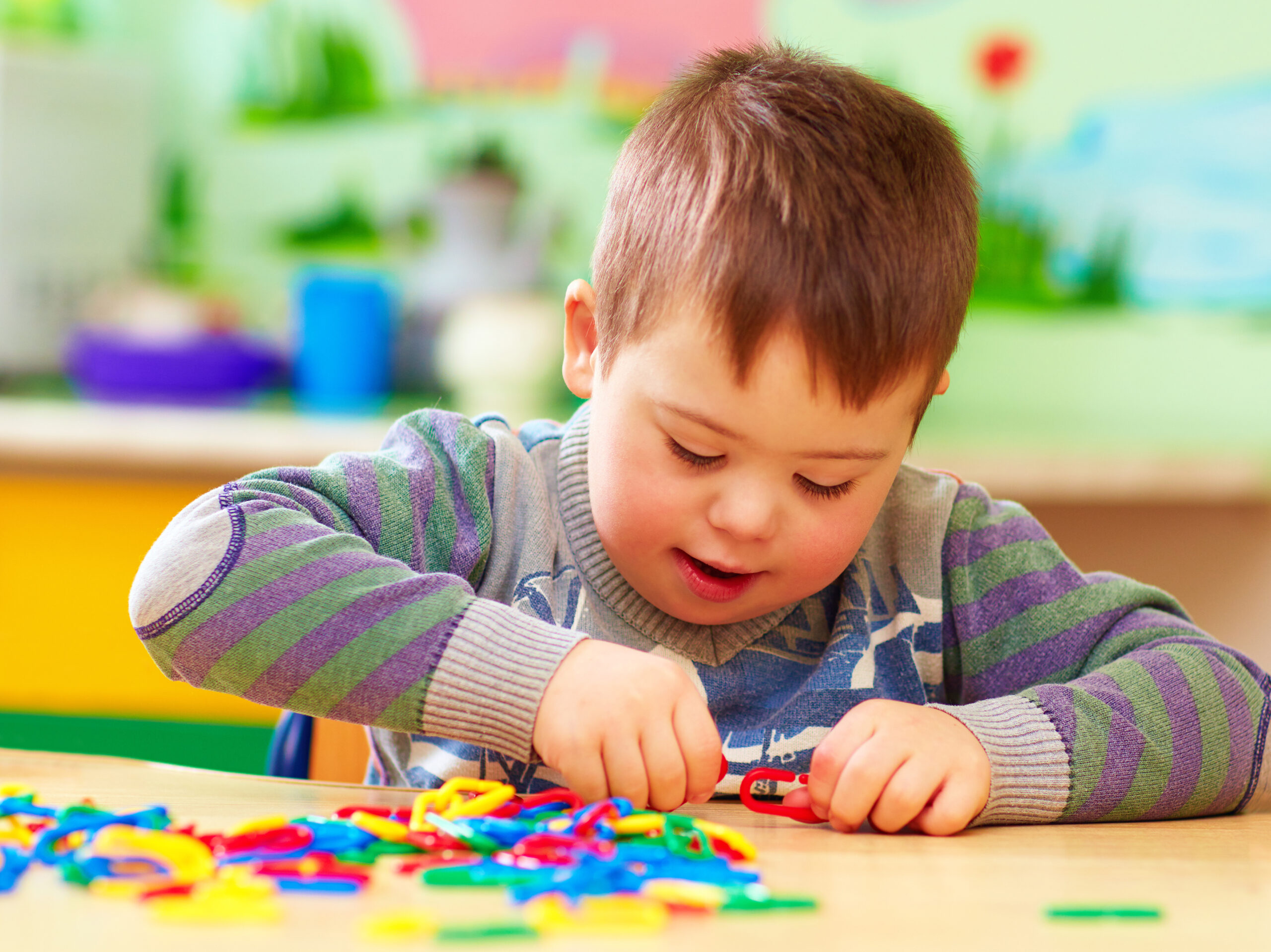 Cute,kid,with,down's,syndrome,playing,in,kindergarten